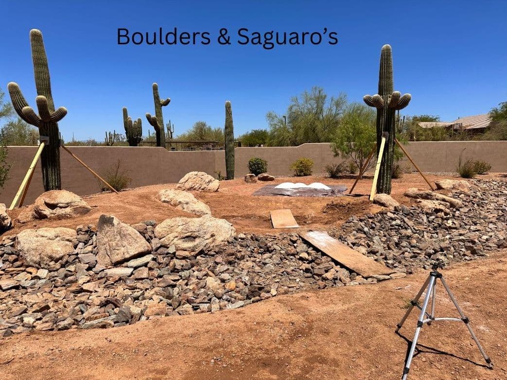 Landscape featuring boulders, saguaro cacti, and a rocky terrain in a desert setting.